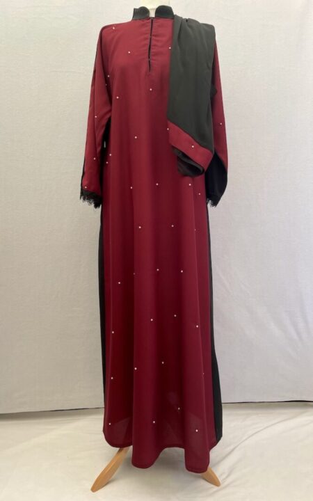 Buy this modest simple cut abaya with a burgundy coloured front that has little tiny pearls sewn across it, while the back panel is plain black. The abaya has matching hijab. It has lace at the wrist and is slip on style.